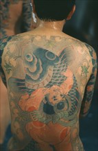 JAPAN, General, Heavily tattooed Yakuza gangster with back to camera.