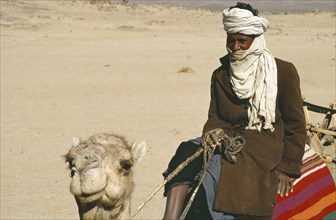 ALGERIA, Tribal People, Cropped view of Tuareg man riding camel.