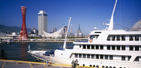 JAPAN, Honshu, Kobe, View over the port area with moored passenger ferry in the foreground and the