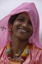 INDIA, Rajasthan, Thar Desert, Portrait of smiling Desert woman wearing pink in Bhansda Village.