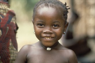 SIERRA LEONE, People, Children, Head and shoulders portrait of young Mende girl smiling .