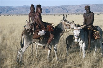 NAMIBIA, Marienfluss, Himba group on donkeys.