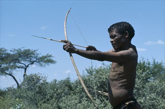 NAMIBIA, Kalahari Desert, Bushman raising bow and arrow.