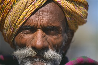 INDIA, Rajasthan, Jaisalmer, Portrait of Rajasthani man wearing  brightly coloured turban.