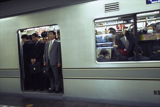 JAPAN, Honshu, Tokyo, Subway train at a platform with passengers crowded on