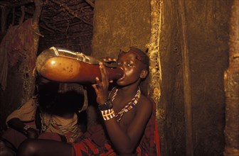 KENYA, , A Maasai Moran drinks traditional honey beer as part of his initiation ceremony into