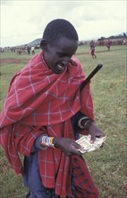 KENYA, , A Maasai man counts money from the sale of his cattle at a cattle market in Southern Kenya