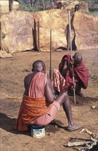 KENYA, Kajiado, Maasai elders prepare the ground for a meat feast  which is part of the initiation