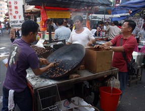 MALAYSIA, Kuala Lumpur, Chinatown, Market stall selling hot snacks cooked in a large wok with