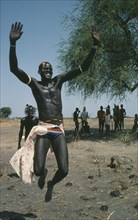SUDAN, People, Dinka tribesman leaping into air.