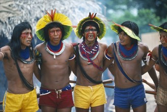 BRAZIL, Amazonas, General, Xikrin Indian men wearing feathered head dresses dancing.