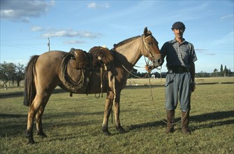 URUGUAY, Farming, Gaucho holding horse.