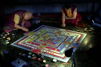 INDIA, Sikkim, Rumtek Gompa, Two monks painting decorative patterns for the Pujar ceremony  and the