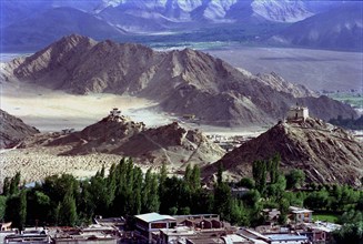 INDIA, Ladakh, Leh, View toward distant hilltop Temples on the outskirts of the town against a