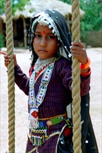 INDIA, Rajasthan, Udaipur, Portrait of a young girl playing on a rope swing