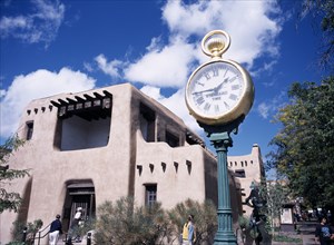 USA, New Mexico, Santa Fe, Museum with typical Adobe architecture and large clock in the foreground