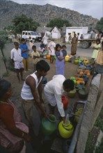 INDIA, Andhra Pradesh, Anantapur, People queuing with their plastic water pots to collect water