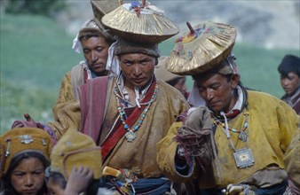 INDIA, Zanskar, Men in gold head dresses who stage a mock abduction to take bridegroom to meet