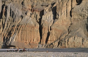 NEPAL, Mustang, High ranking Tibetan lama and Monks travelling across landscape by sheer cliffs to
