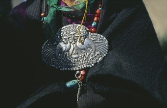 NEPAL, Mustang, Detail of family heirloom brooch with embossed peacocks