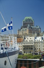 CANADA, Quebec, View of the Chateau Frontenac seen from moored boat flying the Quebec Flag