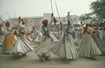 INDIA, Rajasthan, Jodhpur, Men dancing for the Maharaja of Jodhpur wearing traditional white robes