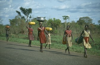 UGANDA, Gulu, Acholi girls walking down the road some carrying baskets on their heads
