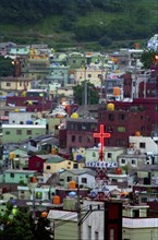 SOUTH KOREA, Pusan, View over housing in city suburb with illumintaed church cross