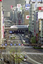 JAPAN, Honshu, Tokyo, Bullet Train passing through the city on raised platform over a main road