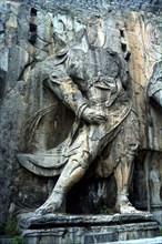 CHINA, Henan, Near Luoyang, Ancient Longmen caves. One of the many beheaded images of Buddha and