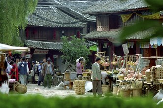 CHINA, Yunnan, Lijiang, Street scene with various market stalls selling household goods