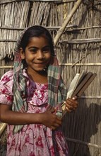 BANGLADESH, Shariatpur, Portrait of young girl smiling holding writing slate.