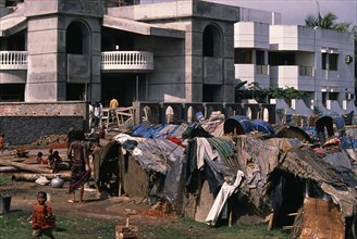 BANGLADESH, Dhaka, Slum dwellings beside luxury homes.