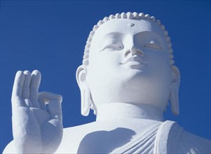 SRI LANKA, Mihintale, Large white seated Buddha.  Detail of head and raised hand.