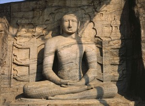 SRI LANKA, Polonnaruwa, Gal Vihara.  Mid twelth century seated Buddha figure carved from granite.