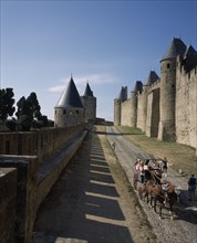 FRANCE, Languedoc Roussillon, Aude, Carcassone. La Cite inner and outer ramparts with hourse drawn