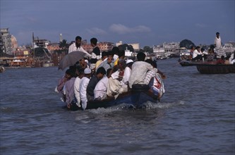 BANGLADESH, Dhaka, Overloaded country boat crossing the Buriganga River
