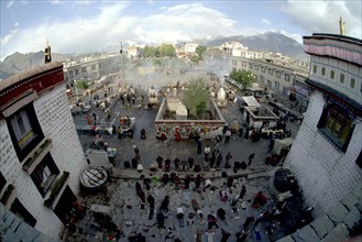 CHINA, Tibet, Lhasa, Wide angle view from the rooftop of the Jokhang Temple over people lying