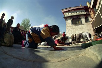 CHINA, Tibet, Lhasa, Wide angle view of  people prostrating themselves outside the Jokhang Temple