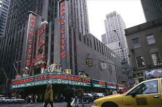 USA, New York, New York, City street scene with Radio City advertising Christmas lineup and yellow