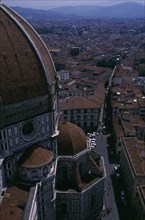 ITALY, Tuscany, Florence, Aerial view of the city streets seen past the domed roof of the Duomo