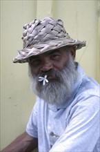 USA, Florida, Key West, Portrait of a man with a flower in his mouth wearing a straw hat