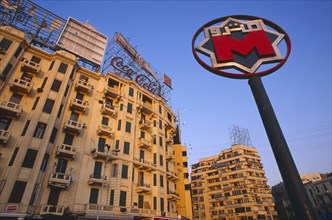 EGYPT, Cairo , Sadat metro station sign on Midan Tahrir with city buildings and advertising for