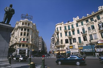 EGYPT, Cairo , Midan Talaat Harb.  Traffic on city road lined by cream coloured buildings with