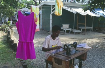 JAMAICA, Ocho Rios, Dressmaker working outside at hand operated sewing machine.
