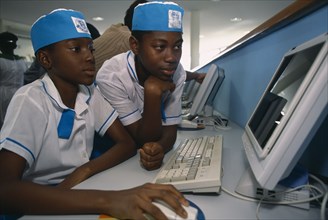 NIGERIA, Abuja, Two children in uniform working on a computer at the British Council