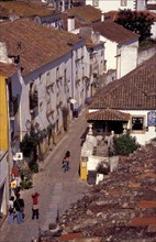 PORTUGAL, Leiria, Obidos, General view over cobbled street and rooftops