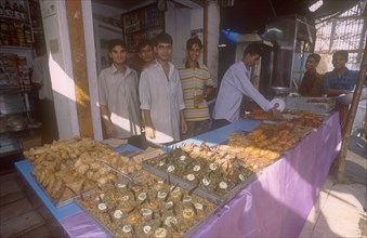 BANGLADESH, Dhaka, Street side shop selling snacks for Iftar. The sunset breaking off the fast in