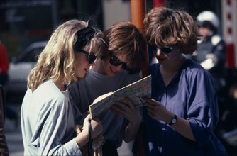 BELGIUM, Brussels, Three female tourists reading a map outside the Grand Palace