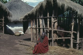 BURUNDI, Gisozi, Tutsi man sitting outside his home and cattle pen.
